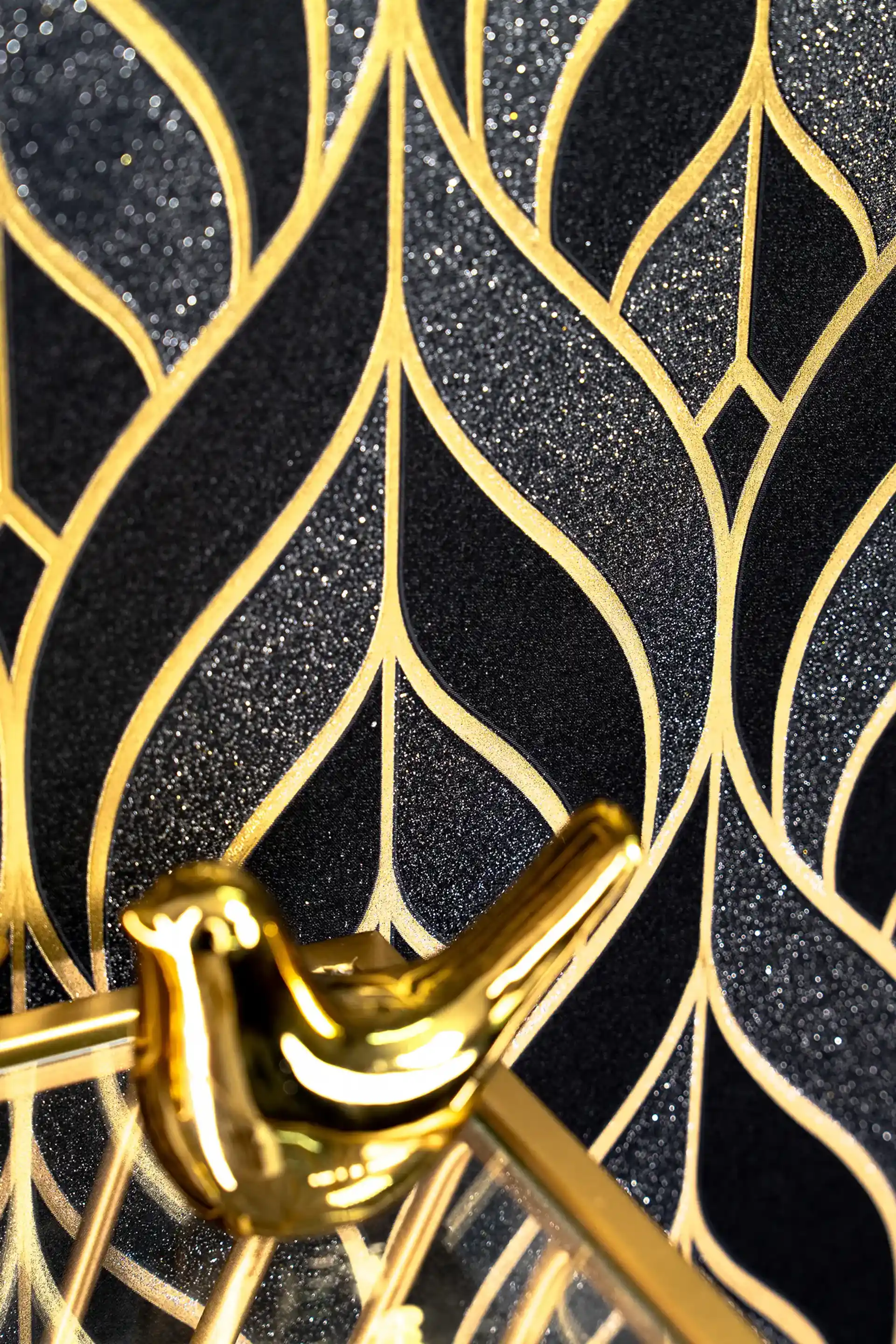 Installed wall showing black and gold leaf pattern wallpaper with sparkle glitters and desk accessories